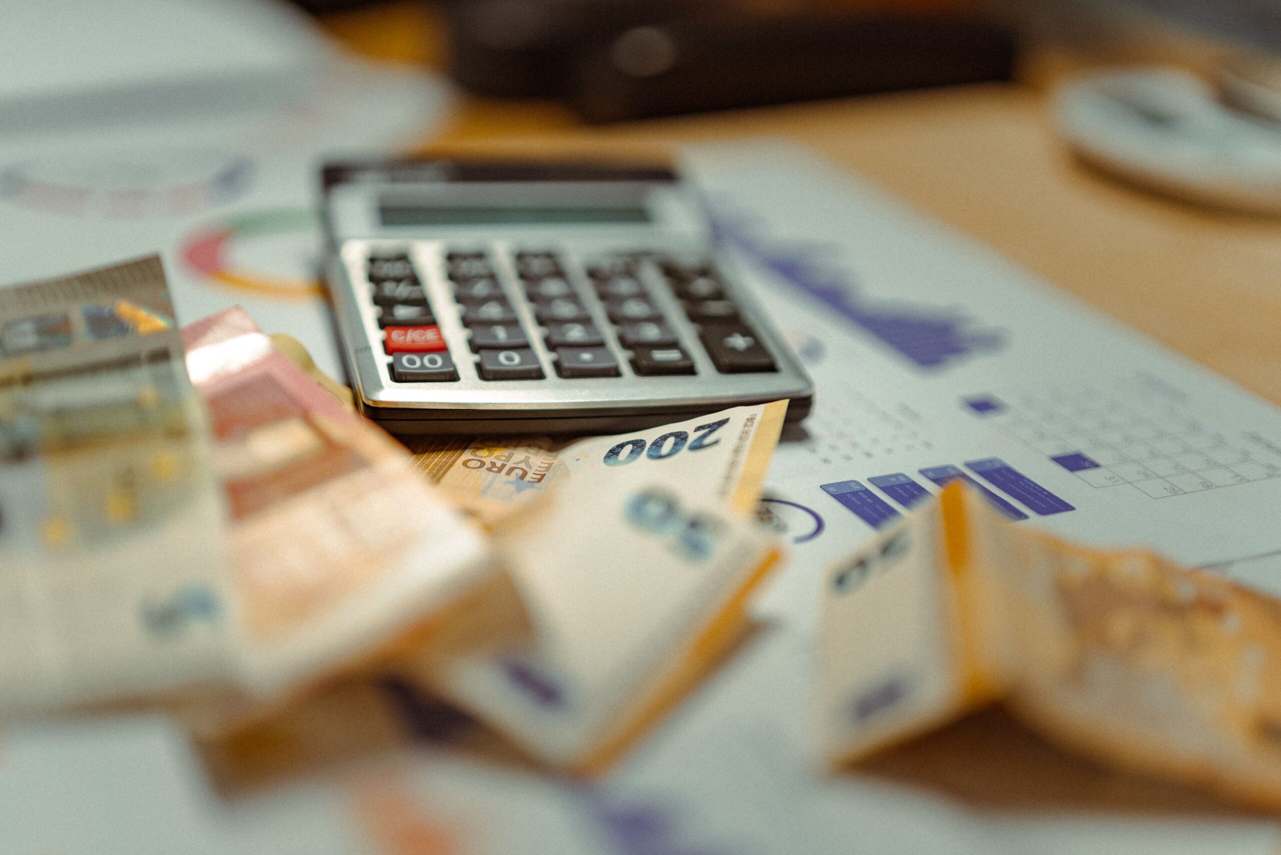 Desk with a calculator, euro notes and tax documents representing Spain's IRPF income tax